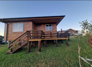 a wooden house with a bench in front of it at Cabañas Chiloé in Dalcahue