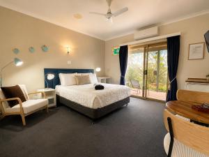 a bedroom with a bed and a chair and a window at Pecan Hill BNB in Toodyay +37 photos