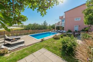 a backyard with a swimming pool and a house at My Dalmatia - Apartment Nostromo in Pag