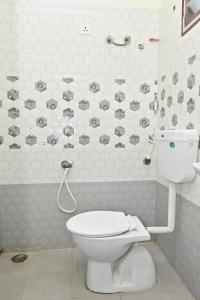 a bathroom with a white toilet in a room at Hotel Siddveer Grand in Guntūr