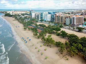 an aerial view of a beach with palm trees and the ocean at ibis Maceio Pajuçara in Maceió