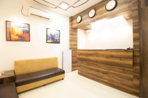 a waiting room with a bench and clocks on the wall at Hotel O Sai Plaza in Aurangabad