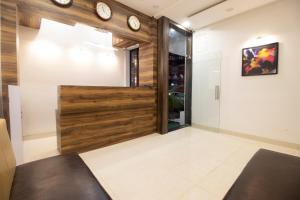 a room with a wooden door and clocks on the wall at Hotel O Sai Plaza in Aurangabad