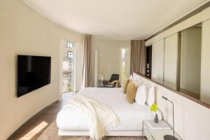 a bedroom with a white bed and a flat screen tv at ME by Meliá London - Covent Garden in London