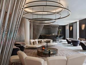 a living room with white furniture and a large chandelier at ME by Meliá London - Covent Garden in London