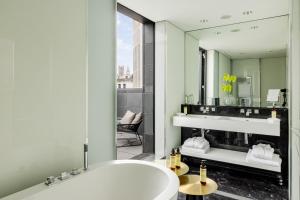 a bathroom with a tub and a large mirror at ME by Meliá London - Covent Garden in London +101 photos