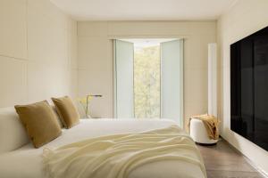 a bedroom with a white bed and a television at ME by Meliá London - Covent Garden in London