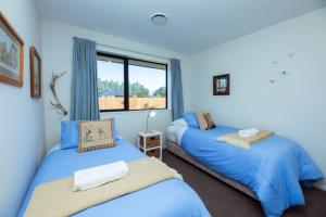 two beds in a blue room with a window at Feels Just Like Home Super Well Equipped For Families And Groups Pet Friendly in Methven