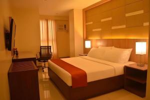 a hotel room with a large bed and a desk at Hotel Veniz - Session in Baguio +51 photos