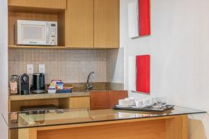 a kitchen with a counter with cups and a microwave at Hotel Brasil 21 Convention, Affiliated by Meliá in Brasília