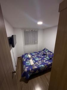 a small bedroom with a bed in a room at Fly At Home Bogotá in Bogotá