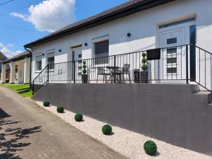 a balcony of a house with a table and chairs at Prime Luxury Apartman in Mátészalka