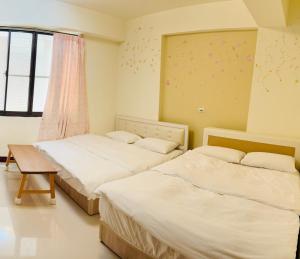 a bedroom with two beds and a window at 易民宿 Min su ji in Tainan +25 photos