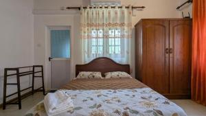 a bedroom with a bed with a wooden headboard and a window at Margarita Leisure in Wadduwa
