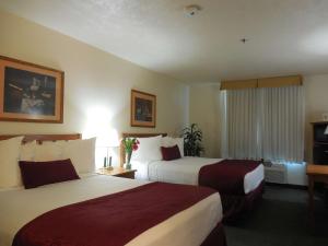 een hotelkamer met 2 bedden en een raam bij Best Western John Jay Inn in Calexico