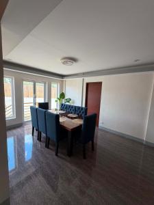 a dining room with a table and blue chairs at Zensole Resort in Tarlac