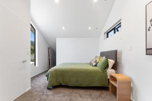 a bedroom with a bed in a white room at Totara tree house in Nelson