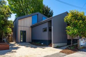 a large metal building with a garage at Totara tree house in Nelson