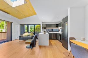 a kitchen and living room with a couch and a table at Totara tree house in Nelson