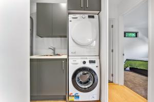 a kitchen with a washing machine and a sink at Totara tree house in Nelson