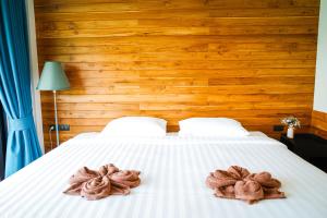a bed with two towels on top of it at Salty Pearl Beach Front Phuket in Patong Beach