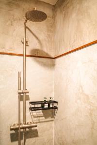 a shower with two bottles on a shelf in a bathroom at Salty Pearl Beach Front Phuket in Patong Beach +39 photos