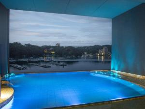 a large swimming pool with a view of a river at Toba Grand Hotel in Toba