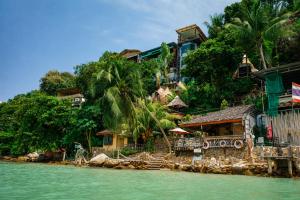 a group of houses on a hill next to the water at Salty Pearl Beach Front Phuket in Patong Beach