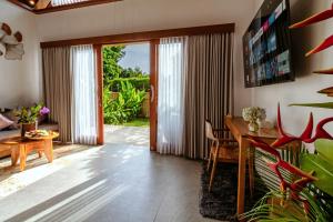 a living room with a wooden table and a dining room at Canvas Escape Resort in Ubud