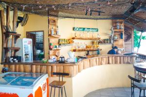 a bar in a restaurant with a man sitting at the counter at Salty Pearl Beach Front Phuket in Patong Beach