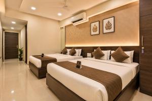 two beds in a hotel room with two beds sidx sidx sidx at Hotel Royal Rituals in Surat