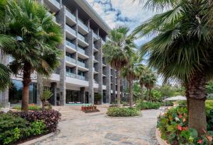 a large building with palm trees in front of it at Gran Meliá Arusha in Arusha