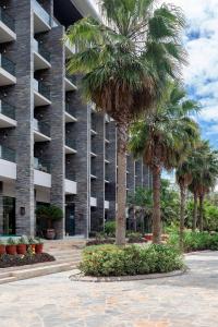 a building with palm trees in front of it at Gran Meliá Arusha in Arusha