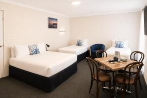 a hotel room with two beds and a table at Busselton Motel in Busselton +17 photos
