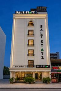 a large white building with a sign on it at Saltstayz Premier - Noida Sector 15 in Noida