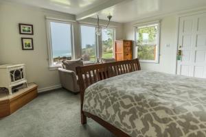 a bedroom with a bed and a tv and windows at SCP Mendocino Coast Lodge in Albion