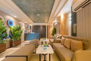 a waiting room with couches and tables at Saltstayz Premier - Noida Sector 15 in Noida