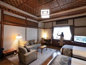 a woman is looking out the window of a hotel room at The Fujiya Hotel in Hakone
