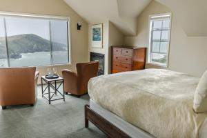 a bedroom with a bed and two chairs and a window at SCP Mendocino Coast Lodge in Albion