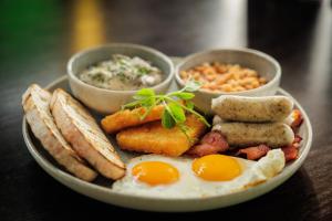 a plate of breakfast food with eggs bread and dips at Carnmore Hotel Lower Hutt in Lower Hutt +26 photos