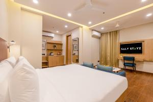 a hotel room with a bed and a living room at Saltstayz Premier - Noida Sector 15 in Noida
