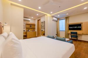 a hotel room with a bed and a tv at Saltstayz Premier - Noida Sector 15 in Noida +61 photos