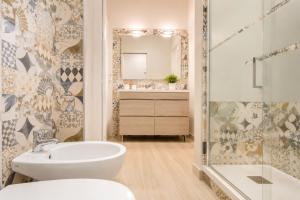 a bathroom with a sink toilet and a mirror at Carducci Mare e Monti in Pescara