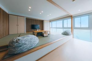 a large living room with a bed and a television at Toba Grand Hotel in Toba