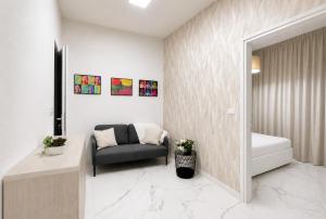 a living room with a chair and a bed in a room at Carducci Mare e Monti in Pescara +6 photos