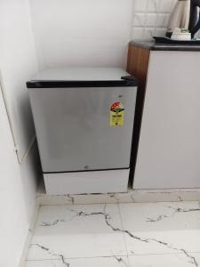 a white refrigerator in a kitchen with a counter at krishna madhavam in Guruvāyūr