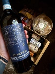 a person holding up a bottle of wine at Glamping Olivia v lese in Radíč