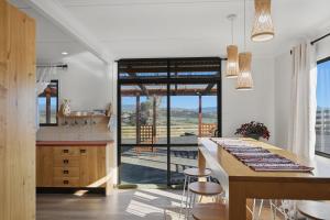 a kitchen with a counter and a table with stools at The Aurora House - BBQ Firepit Stargazing in Tea Tree