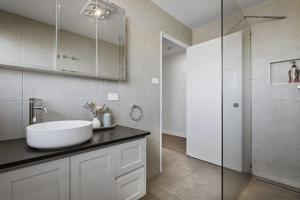 a bathroom with a sink and a shower at The Aurora House - BBQ Firepit Stargazing in Tea Tree