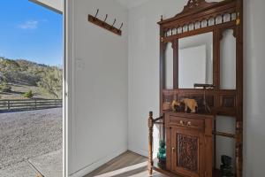 a room with a mirror and a wooden dresser at The Aurora House - BBQ Firepit Stargazing in Tea Tree